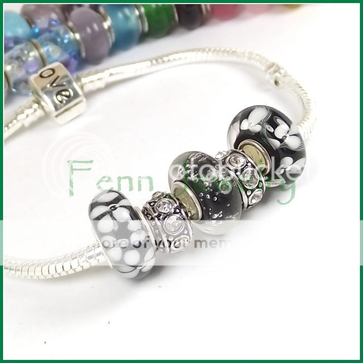   charm bracelet featuring 3 handmade lampwork glass beads with silver